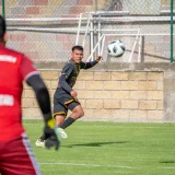 Exciting midair action captured during a soccer match in Texcoco, Mexico, featuring a player and goalkeeper.