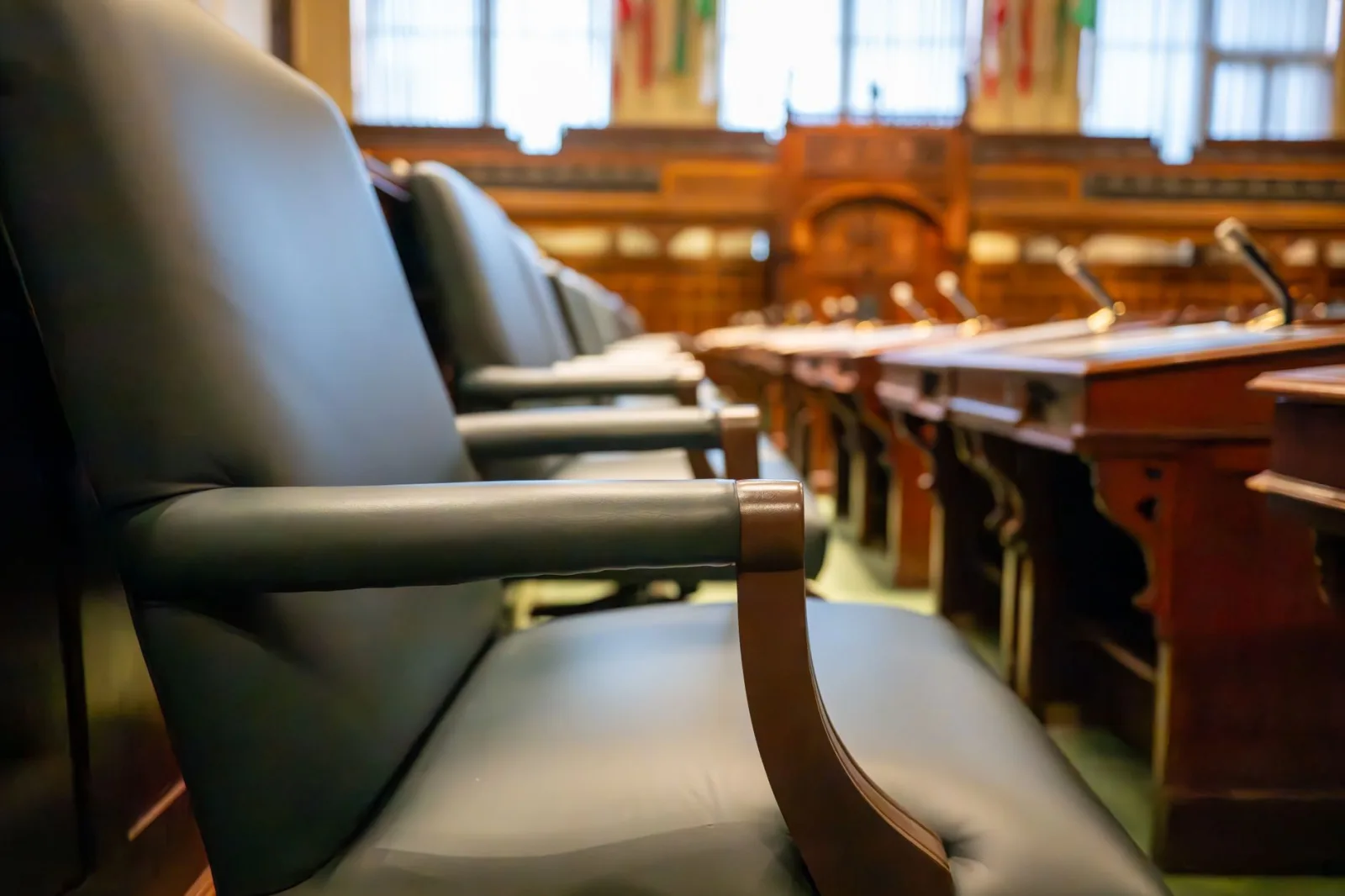 Asientos elegantes en una sala de juicio, con sillas de cuero y escritorios de madera, que transmiten una sensación de autoridad.