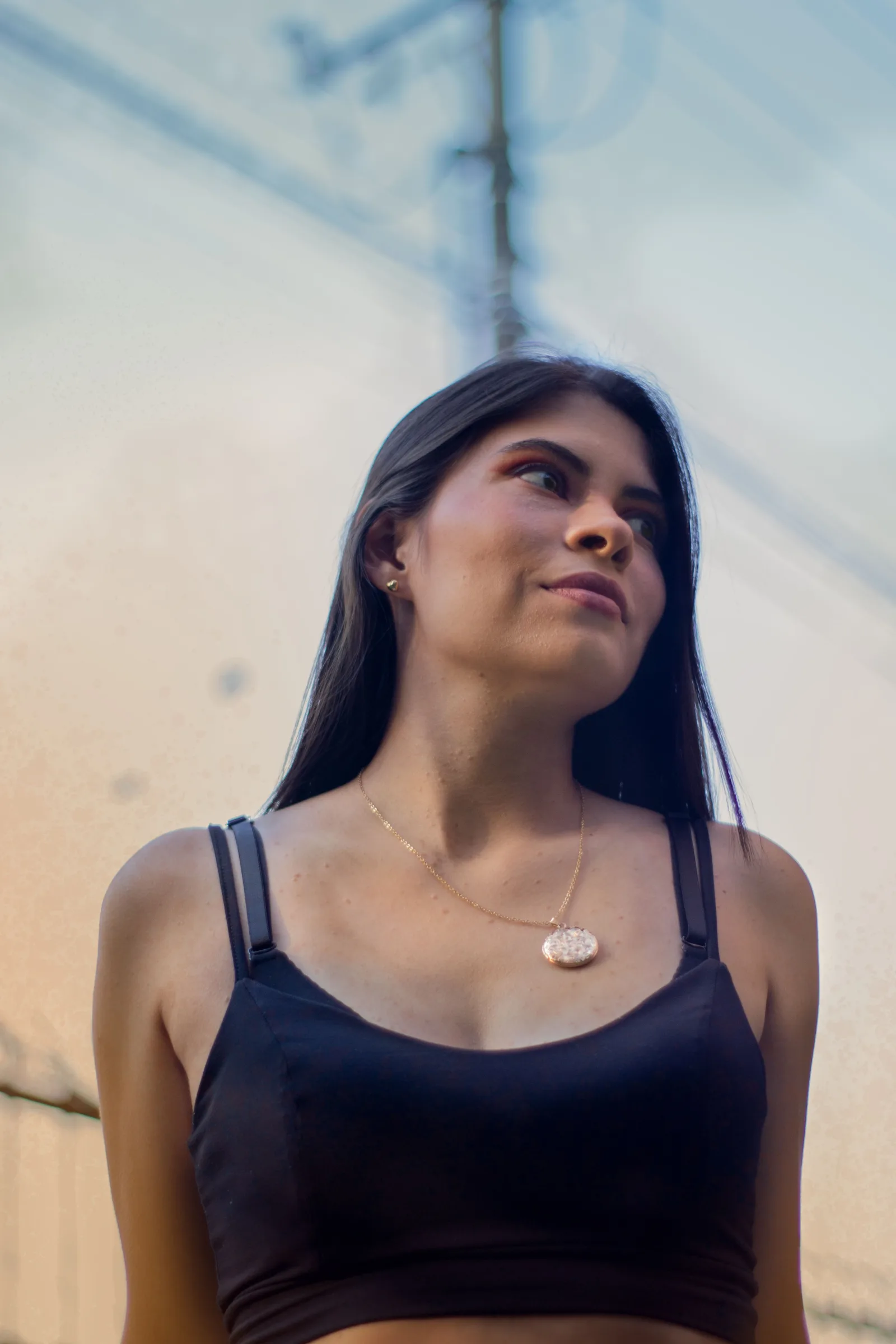 Una mujer posando al aire libre en Villavicencio, Colombia, con una camiseta sin mangas negra.