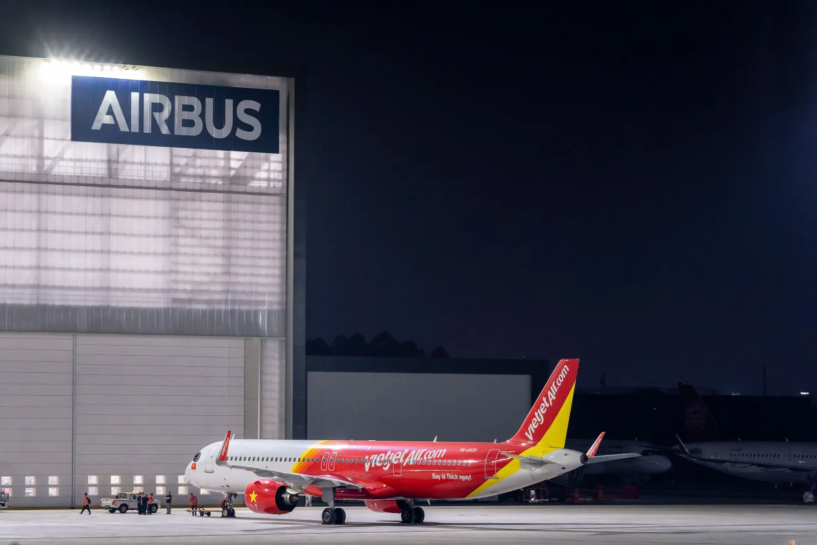 Avión de VietJet Air en un hangar de Airbus, elegante escena nocturna en el aeropuerto.