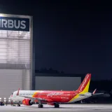Avión de VietJet Air en un hangar de Airbus, elegante escena nocturna en el aeropuerto.