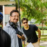 Equipo de filmación trabajando en exteriores con su equipo, capturando momentos espontáneos.