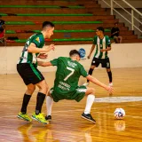 Emocionante partido de fútbol sala en un pabellón, con atletas compitiendo en una cancha de madera pulida.