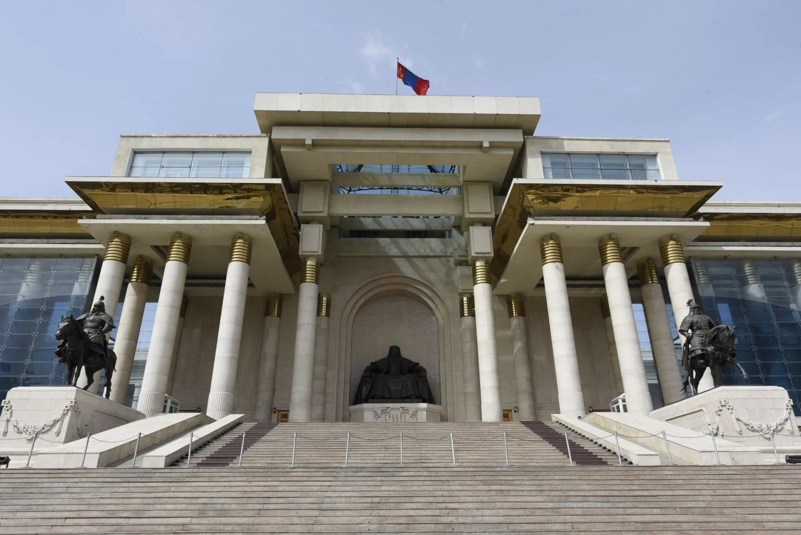 Vista frontal del histórico Palacio de Gobierno de Ulán Bator, con la estatua de Gengis Kan y columnas.