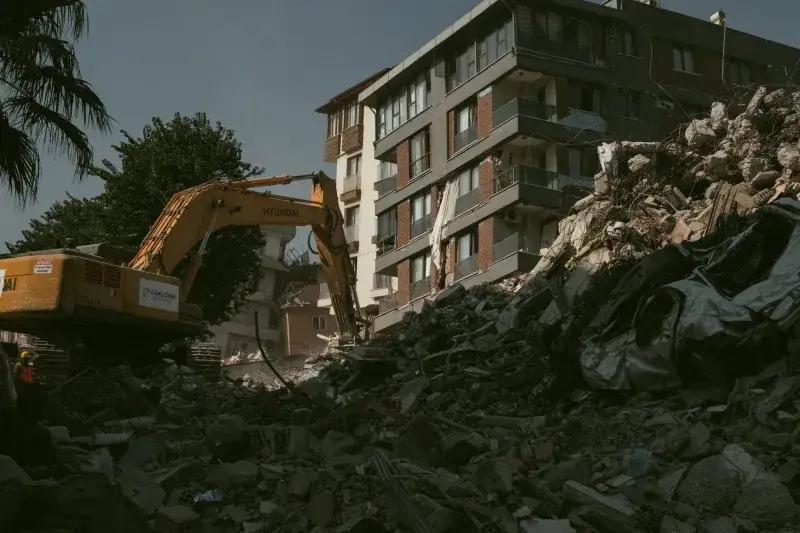 Excavator removing rubble from a collapsed building area in Antakya, Türkiye.