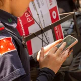 Policía uniformado usando un teléfono inteligente al aire libre en Londrina, Brasil.