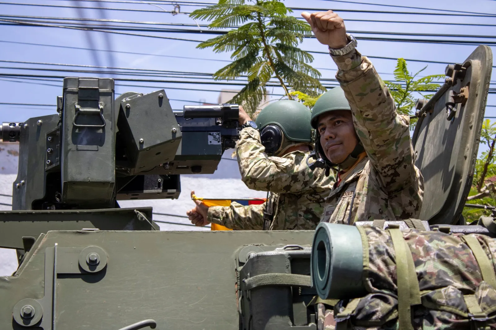 Soldados con equipo de camuflaje a bordo de un vehículo blindado, mostrando preparación militar y trabajo en equipo.