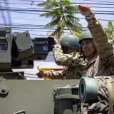 Soldados con equipo de camuflaje a bordo de un vehículo blindado, mostrando preparación militar y trabajo en equipo.