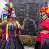 Colorful Día de los Muertos celebration with face paint and traditional Mexican costumes in CDMX.