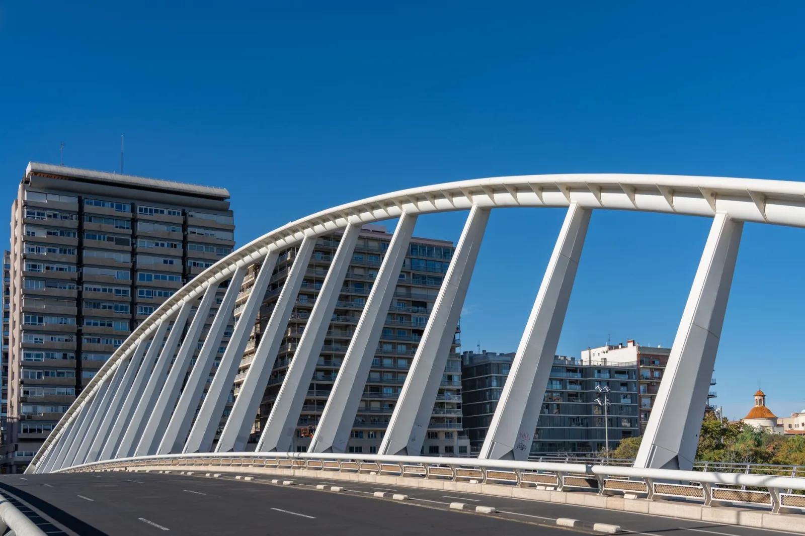 Vista minimalista de un puente blanco y el perfil urbano de Valencia, España