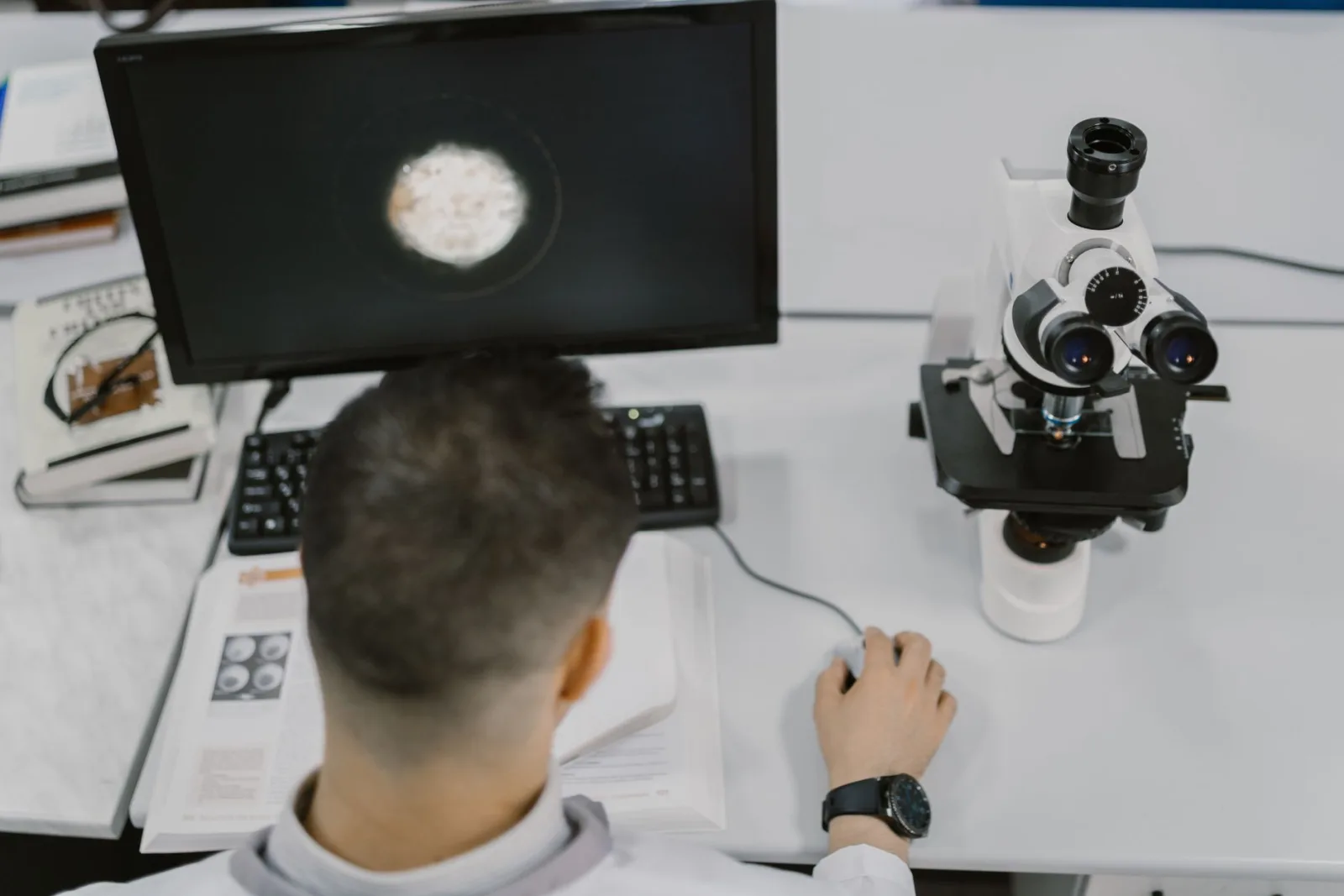 Científico trabajando con un microscopio en un laboratorio moderno.