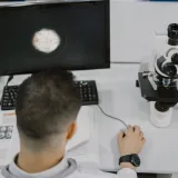 Científico trabajando con un microscopio en un laboratorio moderno.