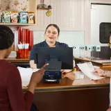 El personal del restaurante toma pedidos en un sistema de punto de venta, mostrando la tecnología moderna en la restauración.