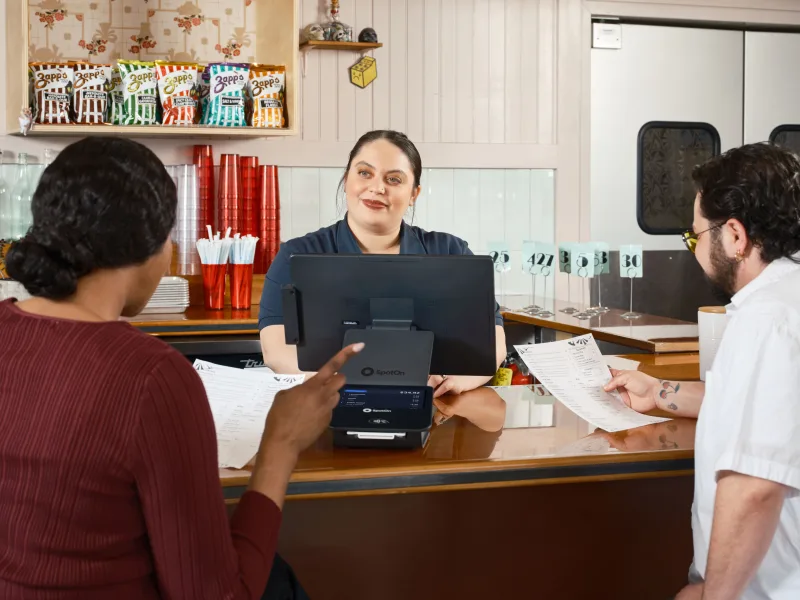 El personal del restaurante toma pedidos en un sistema de punto de venta, mostrando la tecnología moderna en la restauración.