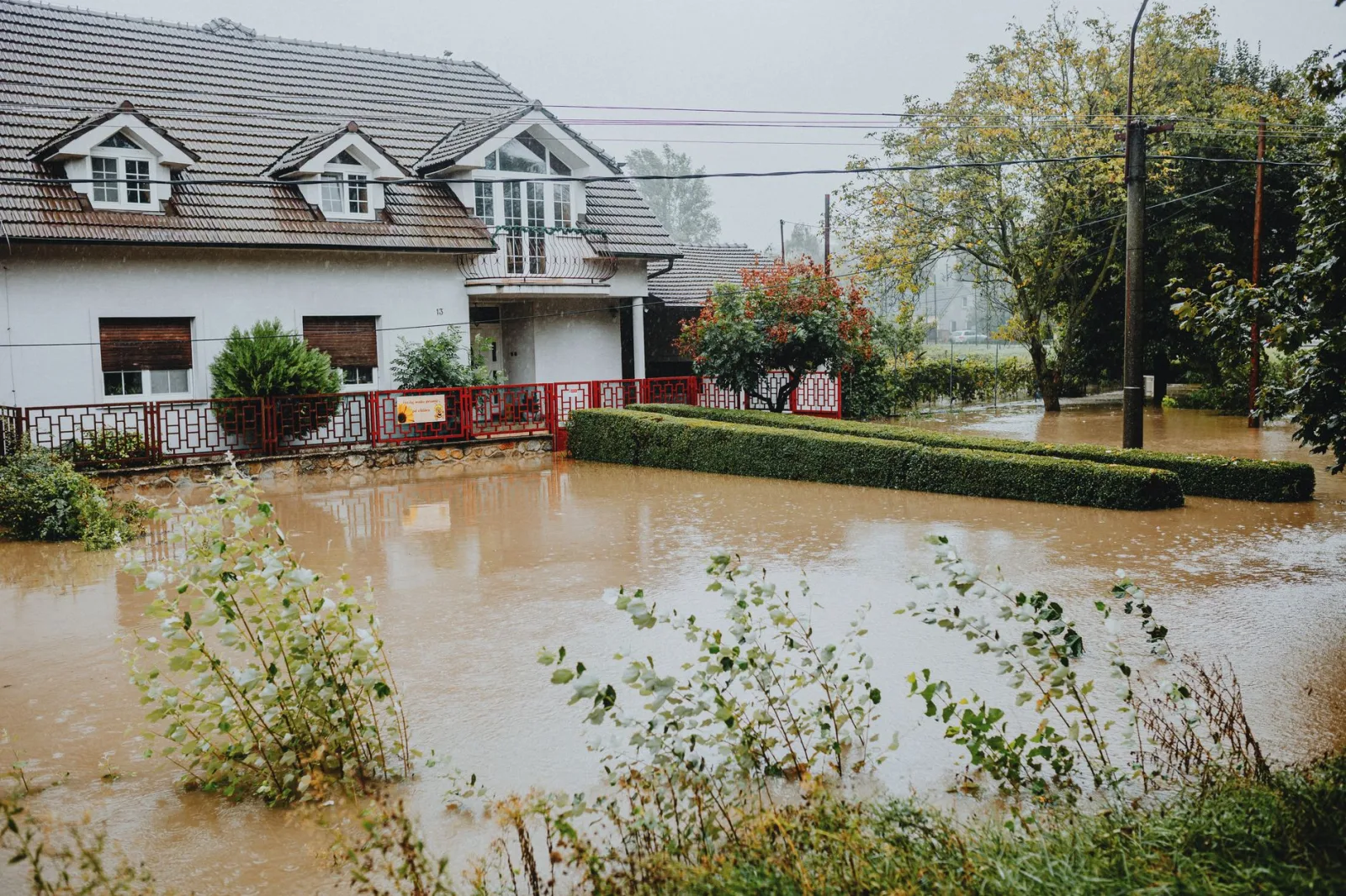 Una casa en las afueras rodeada por aguas de inundación tras fuertes lluvias, que muestra el impacto de un desastre natural.