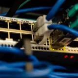 Primer plano de cables Ethernet conectados a un conmutador de red, que muestra la infraestructura informática.