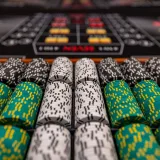 Primer plano de fichas de casino de colores dispuestas sobre una mesa de juego, listas para jugar.