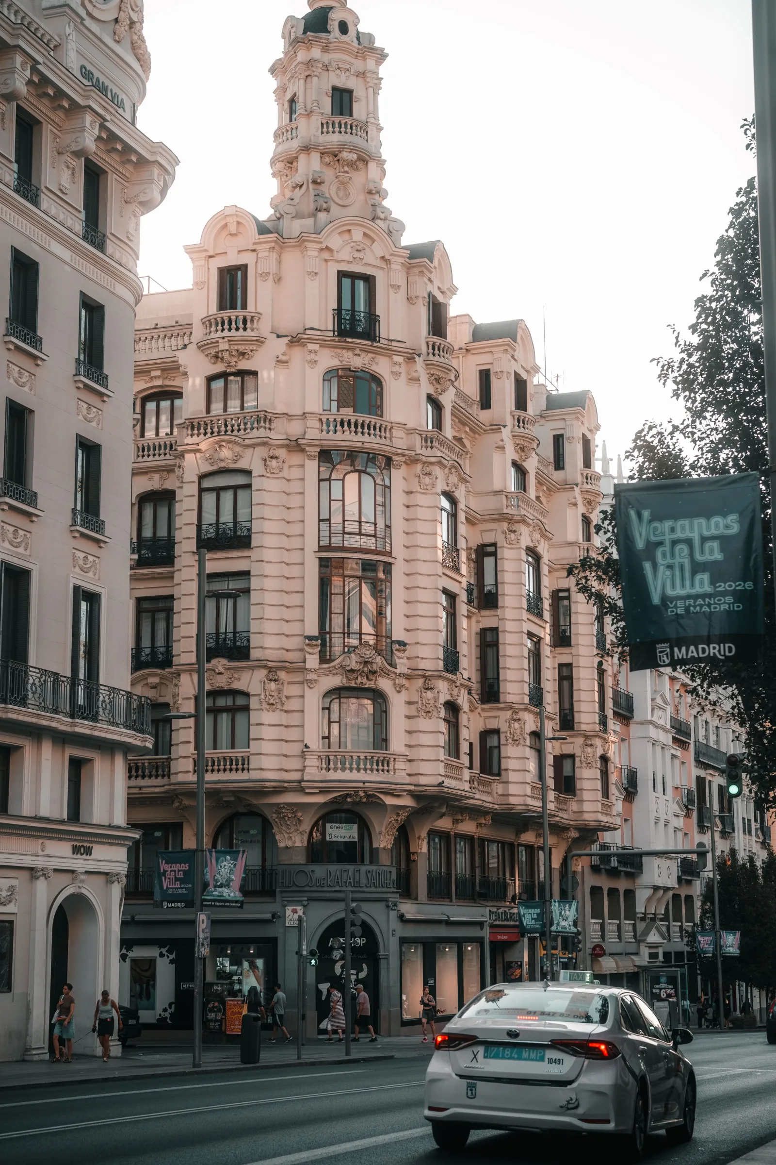 Vista de edificios históricos en Madrid con detalles ornamentados y tráfico urbano.