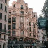 Vista de edificios históricos en Madrid con detalles ornamentados y tráfico urbano.