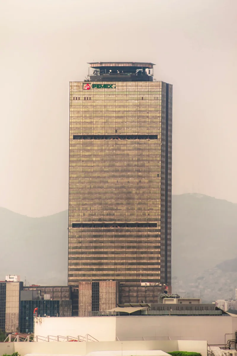 La icónica Torre Ejecutiva de Pemex se alza imponente en el horizonte de la Ciudad de México, envuelto en niebla.
