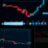 Close-up of cryptocurrency market charts on multiple screens showcasing trading data and trends.