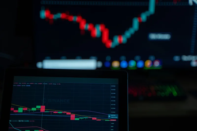 Close-up of cryptocurrency market charts on multiple screens showcasing trading data and trends.