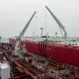 Huge oil tanker equipped with cranes docked at sea. Industrial maritime transportation.