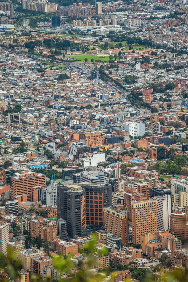 A vibrant aerial cityscape of Bogotá, Colombia, showcasing modern architecture and dense urban environment.