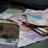 A mix of international banknotes and coins displayed on a table, highlighting diverse world currencies.