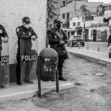Agentes de policía con mascarillas en una acera de la ciudad, velando por la seguridad pública.