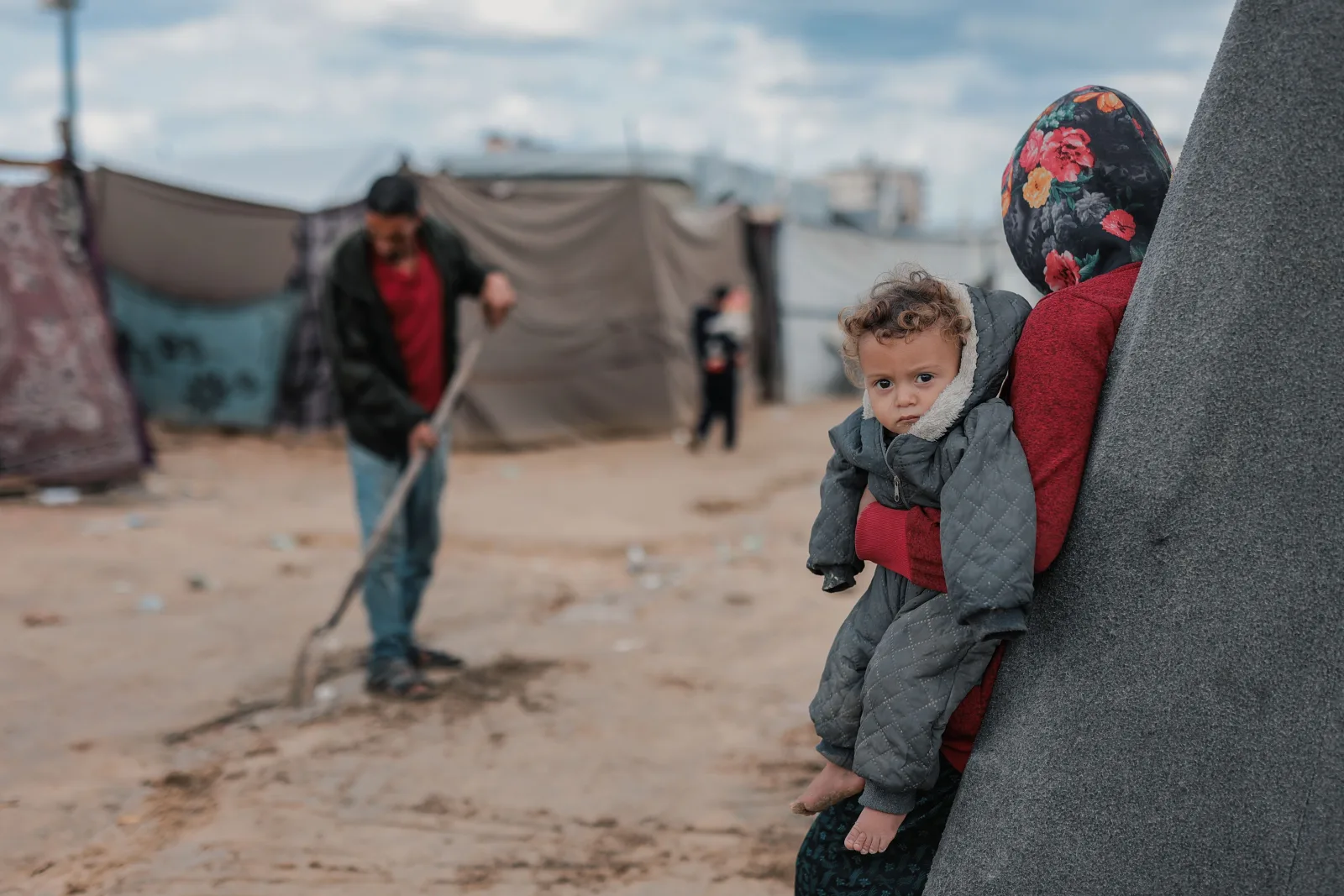 Una escena conmovedora de una madre y su hijo en un campamento de refugiados en Gaza, que destaca la resiliencia.