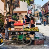 Vibrant street market scene with a fruit vendor in Cartagena, Colombia's historic district.
