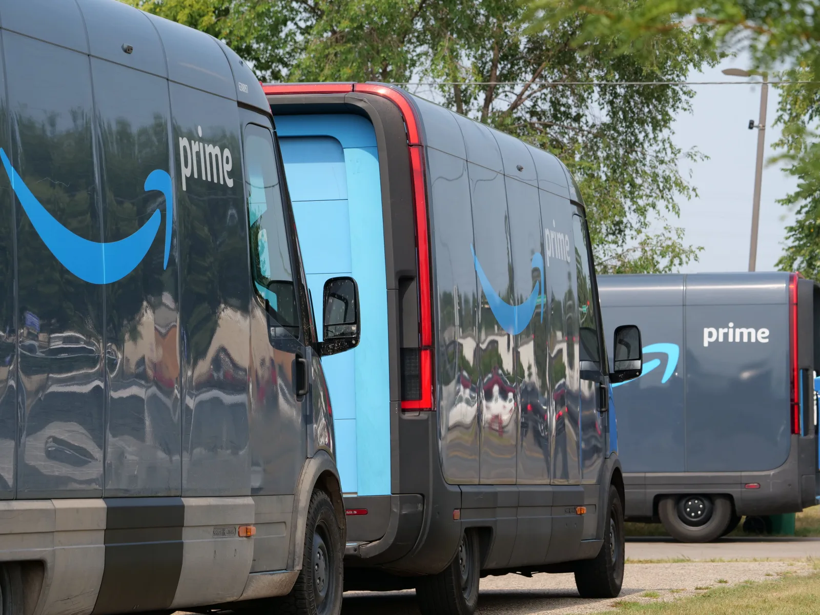 Furgonetas de entrega de Amazon Prime alineadas para operaciones logísticas en un entorno urbano.
