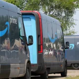 Furgonetas de entrega de Amazon Prime alineadas para operaciones logísticas en un entorno urbano.