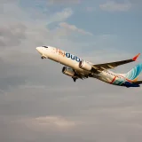 Un avión de pasajeros Boeing 737 de Flydubai despegando al atardecer en Batumi, Georgia, con cielos despejados.