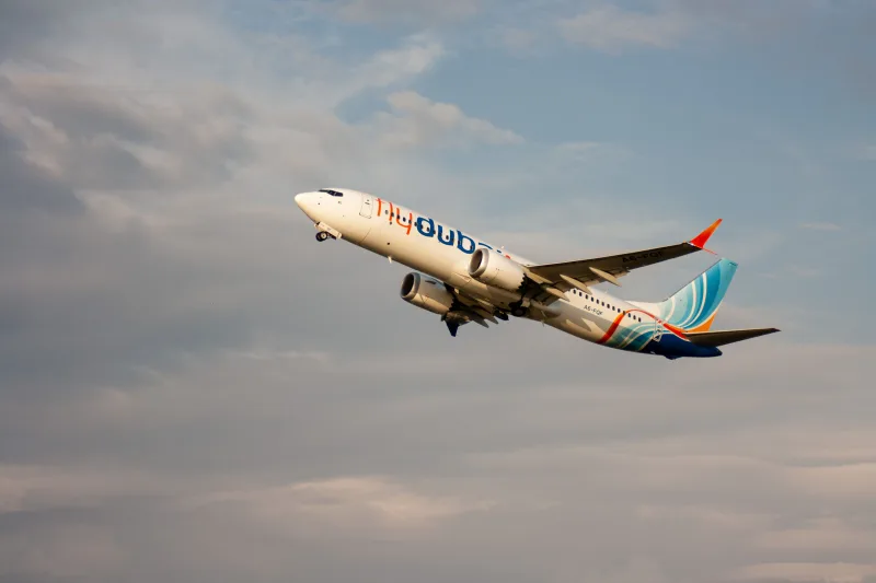 Un avión de pasajeros Boeing 737 de Flydubai despegando al atardecer en Batumi, Georgia, con cielos despejados.