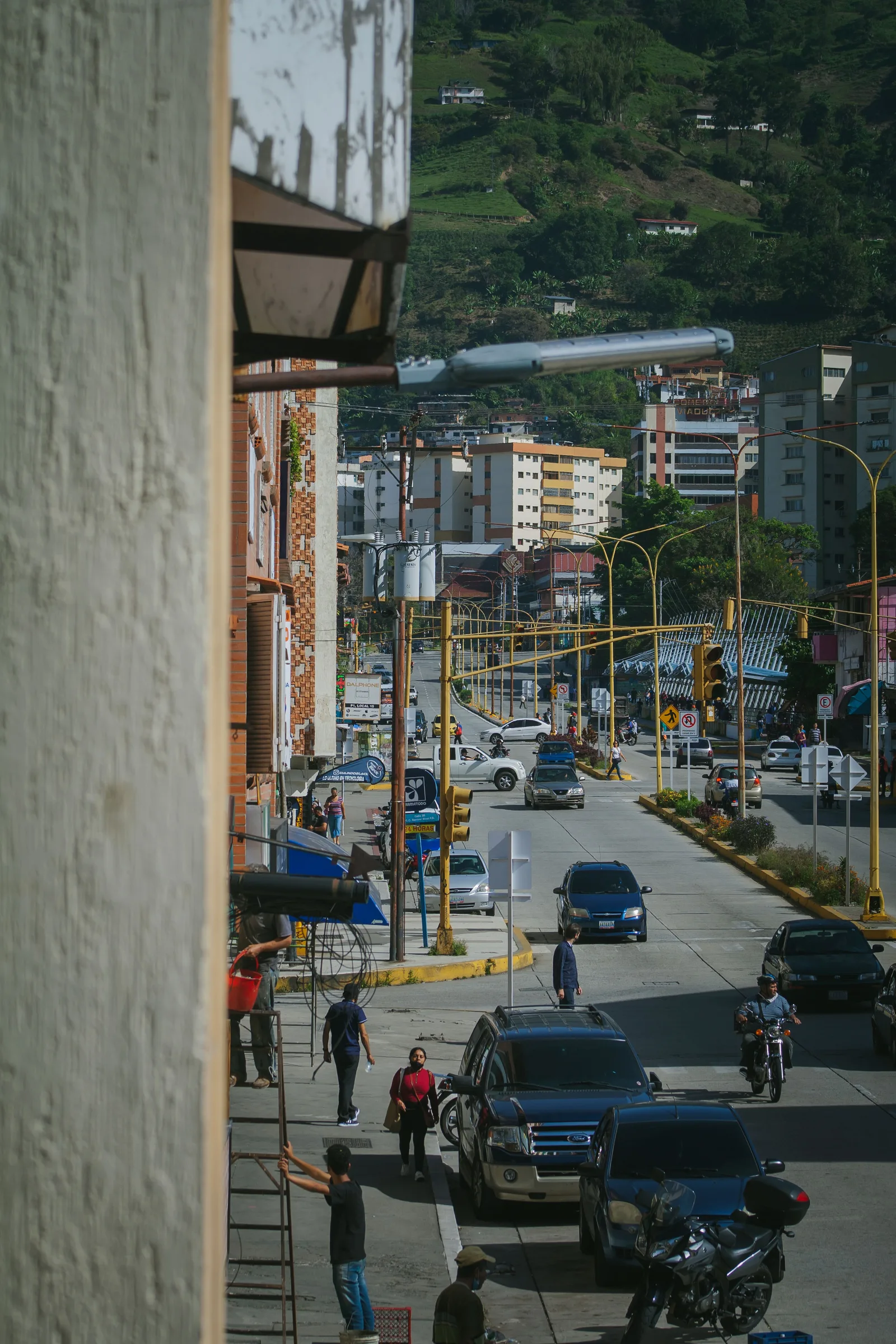Animada calle urbana en Venezuela que muestra la vida cotidiana de la ciudad, con automóviles y peatones.