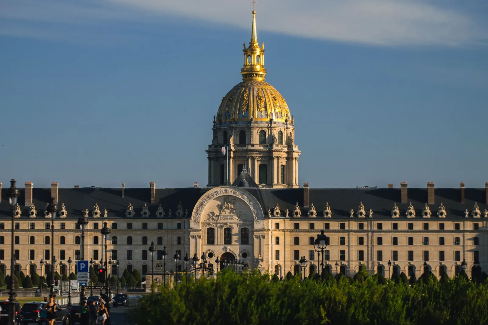 La majestuosa cúpula de Los Inválidos, en París, Francia, iluminada por la luz del día bajo un cielo azul.