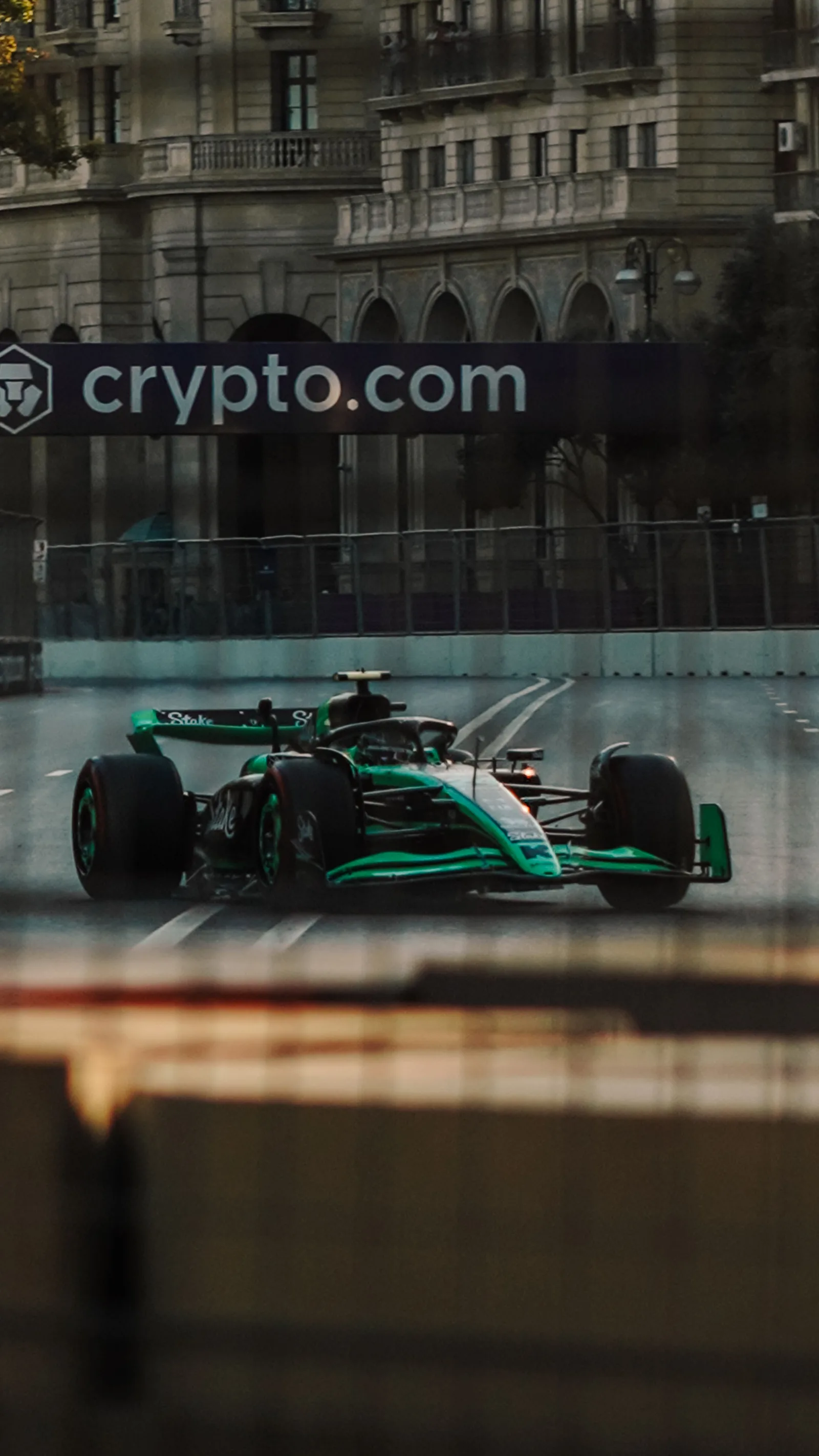 Un coche de Fórmula 1 pasa a toda velocidad junto a un letrero de Crypto.com en un circuito urbano.