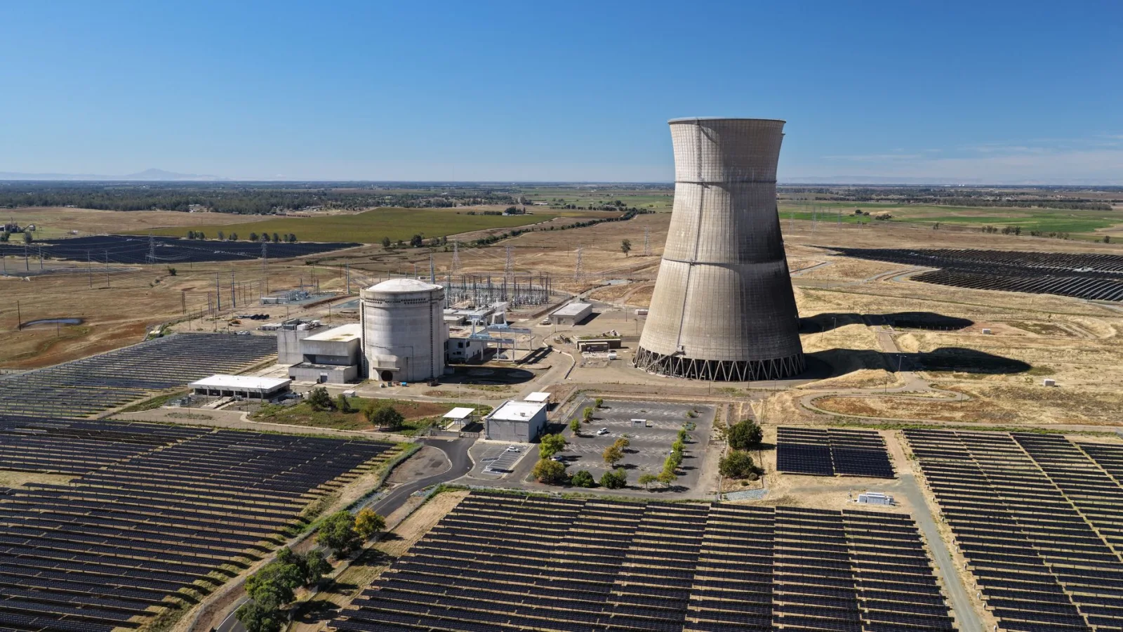 Vista aérea de la central solar Rancho Seco, con una gran torre de refrigeración y paneles solares.