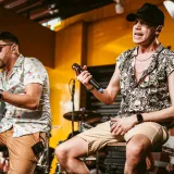 Energetic indoor performance featuring two male vocalists on stage.