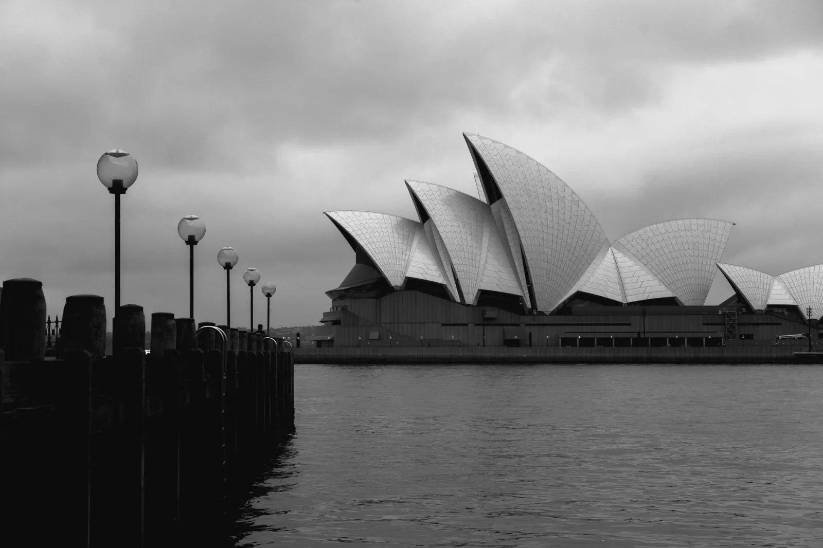 Fachada geométrica en blanco y negro de la moderna Ópera de Sídney en estilo expresionista situada en el embarcadero en un día nublado