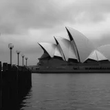 Fachada geométrica en blanco y negro de la moderna Ópera de Sídney en estilo expresionista situada en el embarcadero en un día nublado