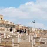 Hombres judíos ortodoxos se reúnen en el cementerio del Monte de los Olivos, en Jerusalén, Israel, bajo un cielo despejado.