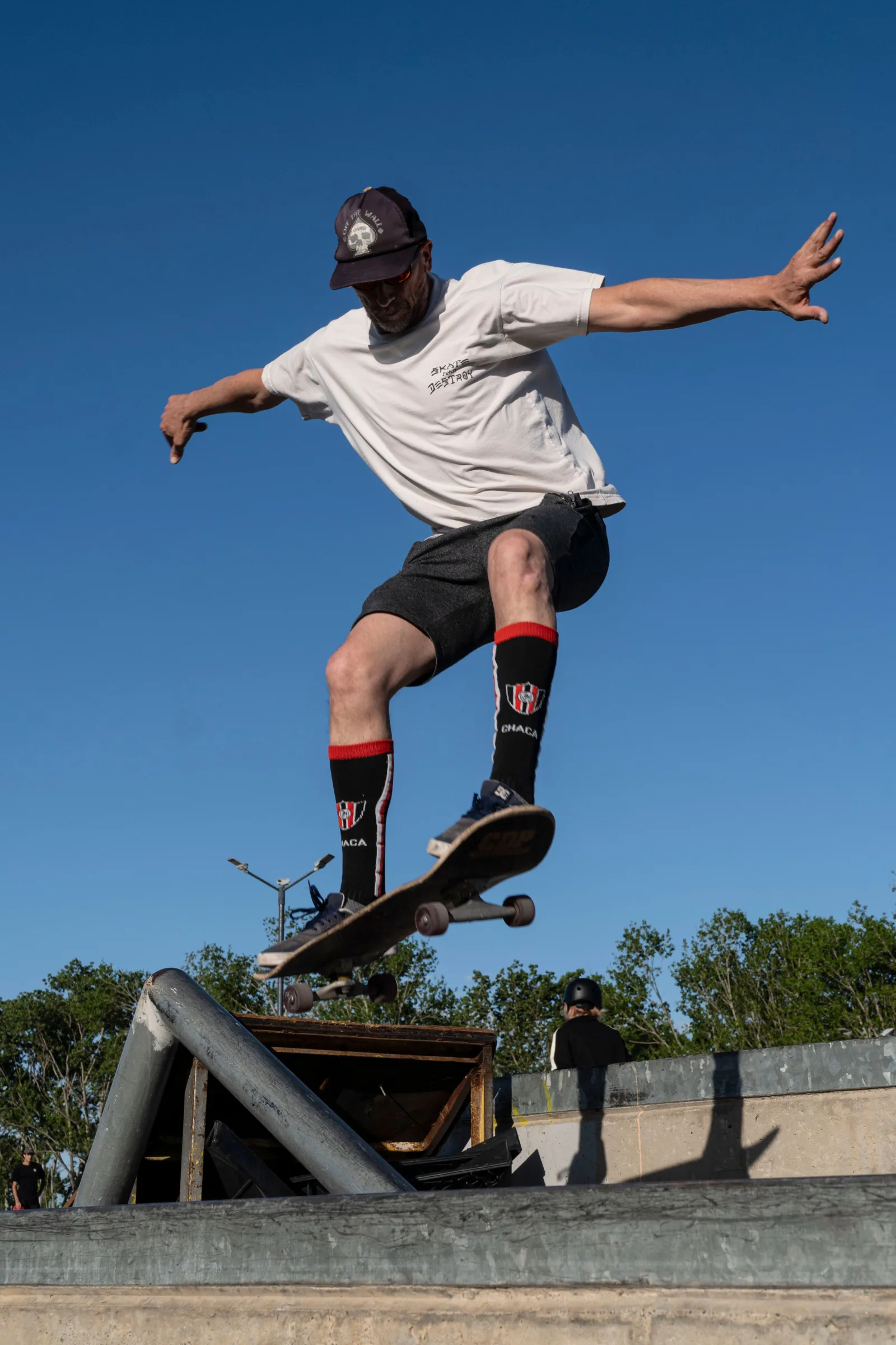 Un patinador en monopatín realiza un salto alto en un parque de skate de Buenos Aires, mostrando sus habilidades en un deporte al aire libre.