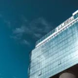 Contemporary skyscraper with reflective glass facade under a clear blue sky in Rosario, Argentina.