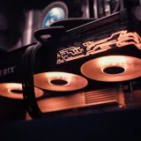 Imagen detallada de una GPU GeForce RTX con luces LED brillantes dentro de una carcasa de computadora.