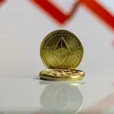 Primer plano de la criptomoneda Ethereum con una flecha roja hacia abajo, simbolizando la caída del mercado.