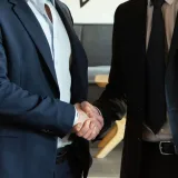 Dos socios de negocios dándose la mano en señal de acuerdo