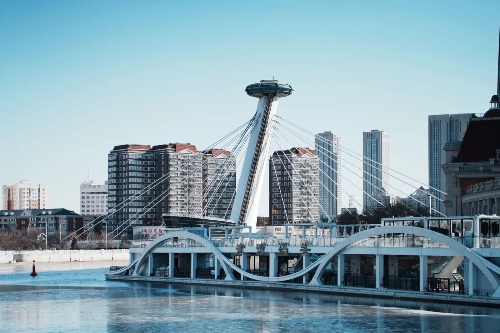 Impresionante vista de la arquitectura moderna y el perfil urbano de Tianjin, China, con cielos azules y reflejos en el río.